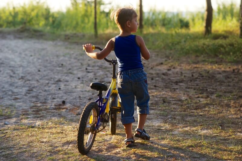 Boy playing outside with his bike