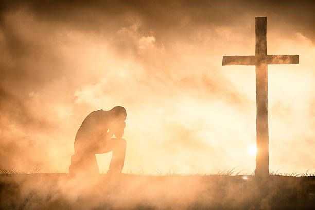 kneeling at the cross of Jesus